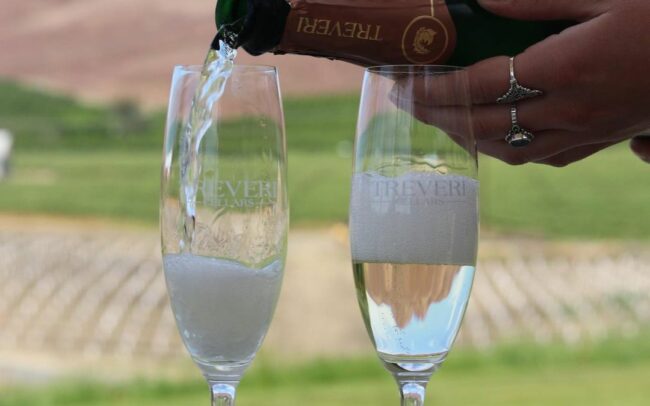 Pouring Treveri Cellars sparkling wine into two flutes
